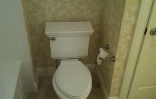 bathroom toilet with wallpaper on walls